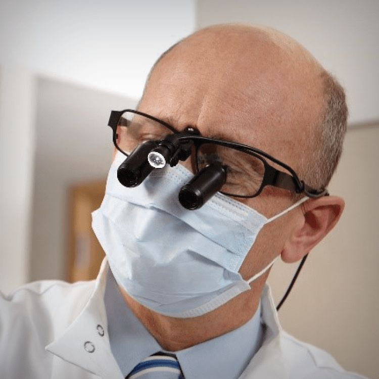 Male medical practitioner with loupes and LED lights